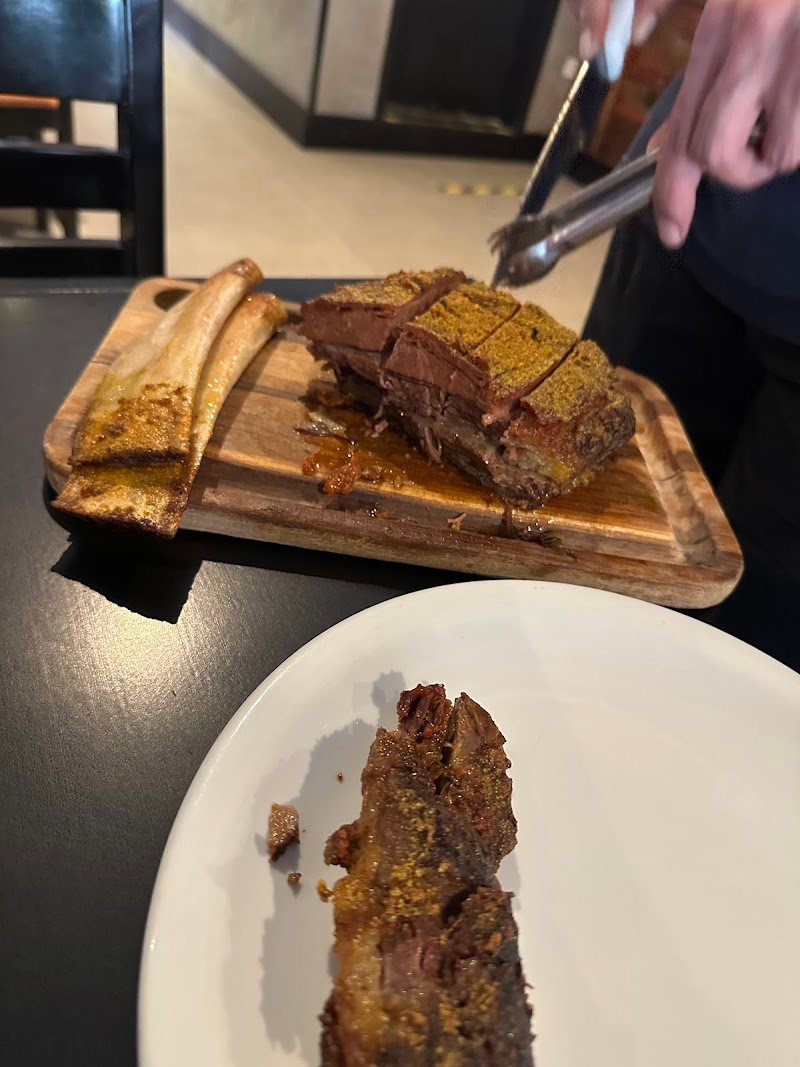 Peça de carne sendo fatiada na tábua no salão